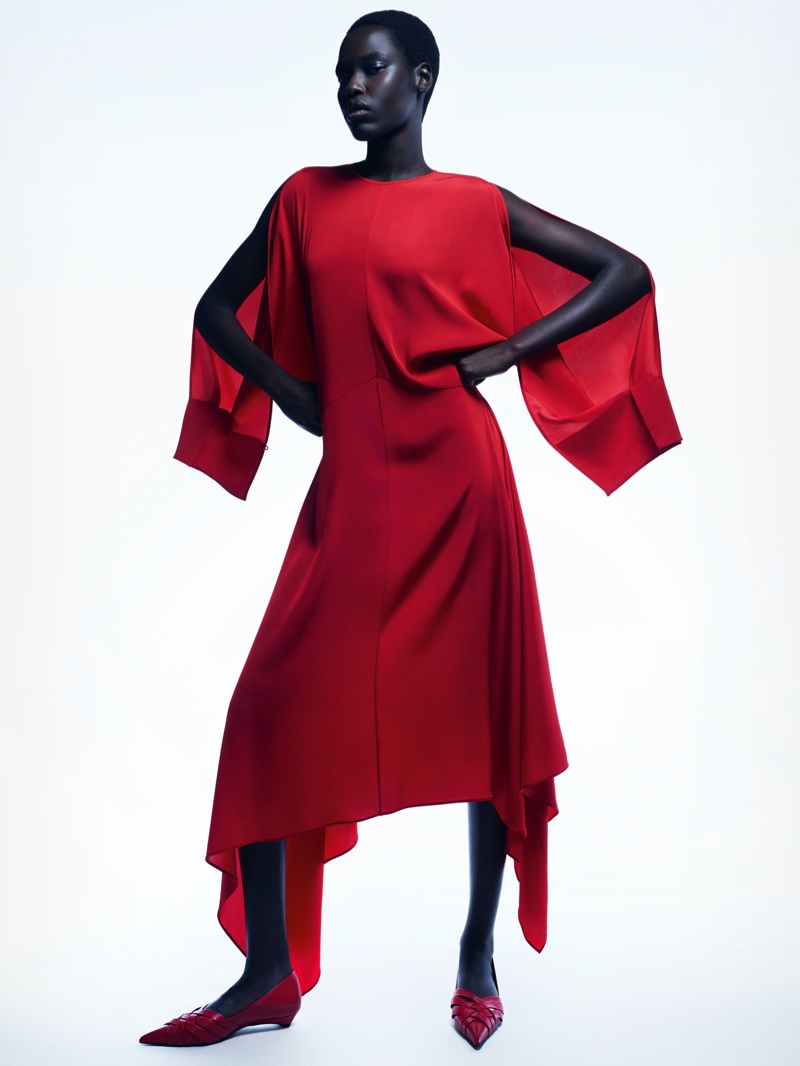 Awar Odhiang strikes a pose in a flowing red dress with extended sleeves in COS spring-summer 2024 ad.