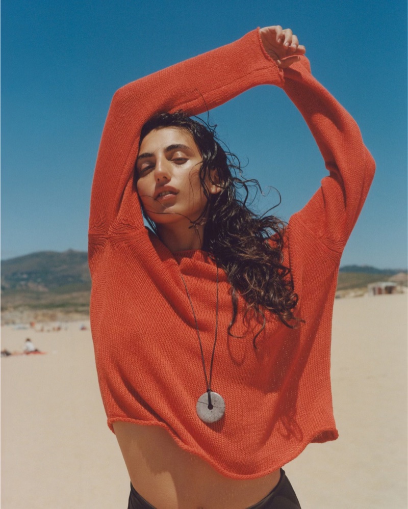 Posing at the beach, Paola Manes shows off an orange linen-blend boat neck sweater from Massimo Dutti.